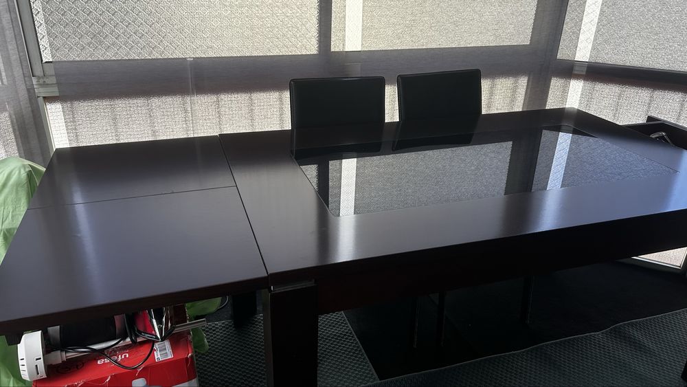 Mesa preta com extensão e cadeiras