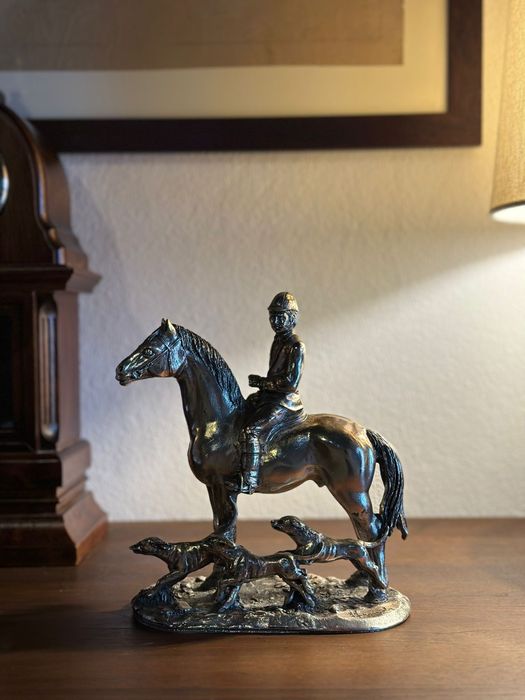 Estátua em metal de cavaleiro com cães