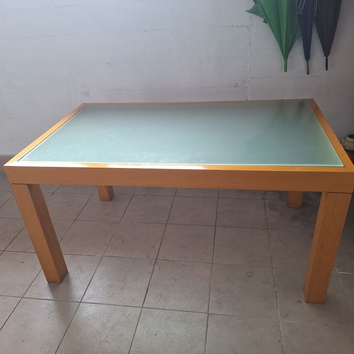 Duas mesas de  madeira com tampo em vidro.