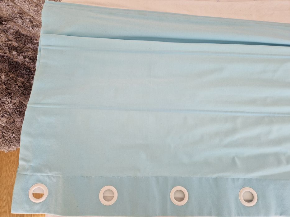 Cortinado azul com ilhos na extremidade