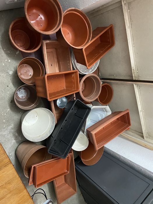 Conjunto composto por varios vasis e floreirasde plastico e a um vaso