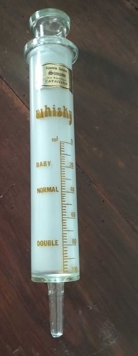 Vintage glass syringe for measuring whisky.