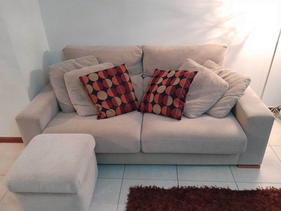 Sofá em tecido, com um puf.