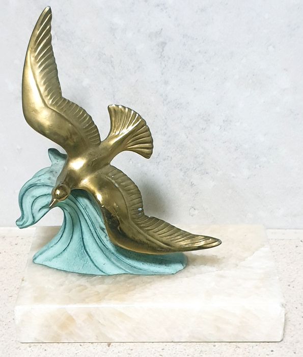 Linda escultura vintage de uma gaivota no mar sobre mármore