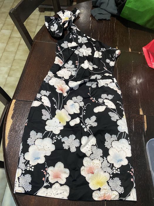 Vestido modelo Oasis Belle uma peça de cocktail com decote de um só onbro e padrão floral sobre fundo preto