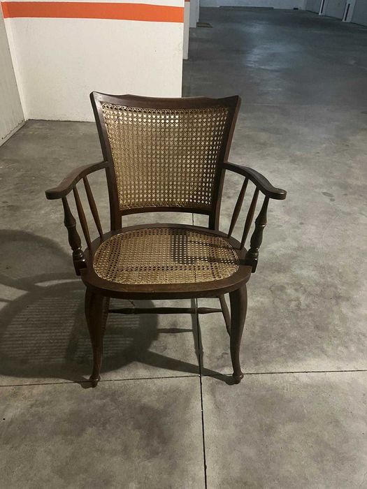 Cadeira de madeira rústica com braços e assento de palha