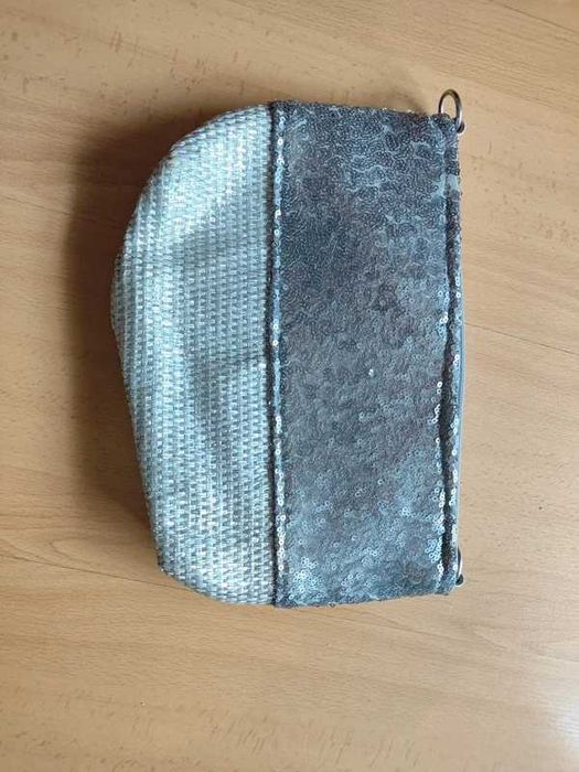 Bolsa de mão prateada com lantejoulas e acabamento em ráfia.