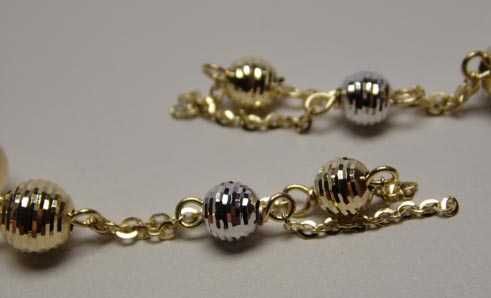 Złote wiszące kolczyki łańcuszki diamentowane dwukolorowe kulki.