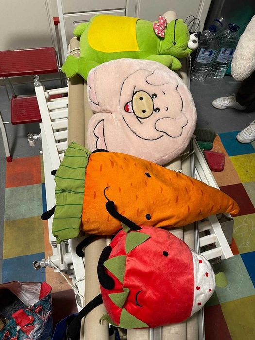 Diversos peluches e almofadas infantis