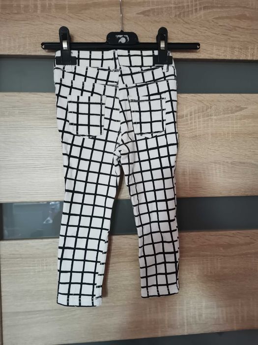 Białe spodnie w czarna kratkę dla dziewczynki firmy H&M.