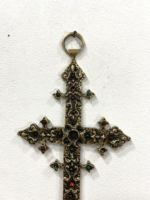 Cruz em metal dourado.
