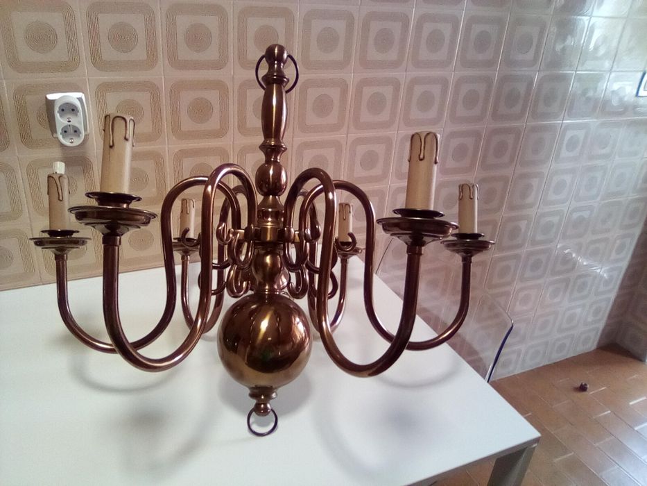 A brass chandelier and 2 sconces with 2 candle-shaped bulbs.