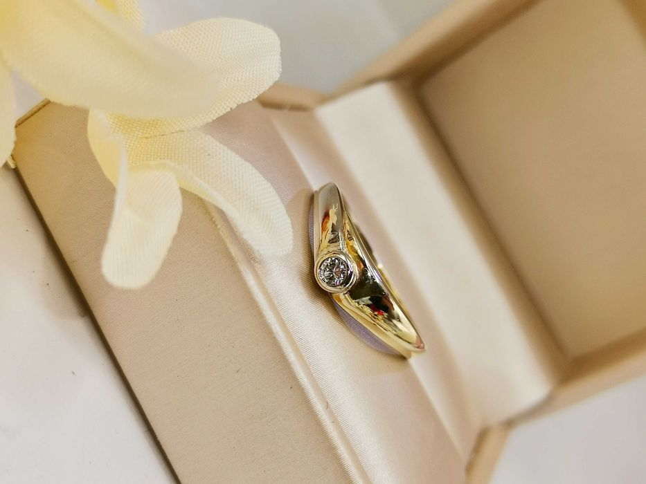 Pierścionek z centralnym brylantem w złocie.