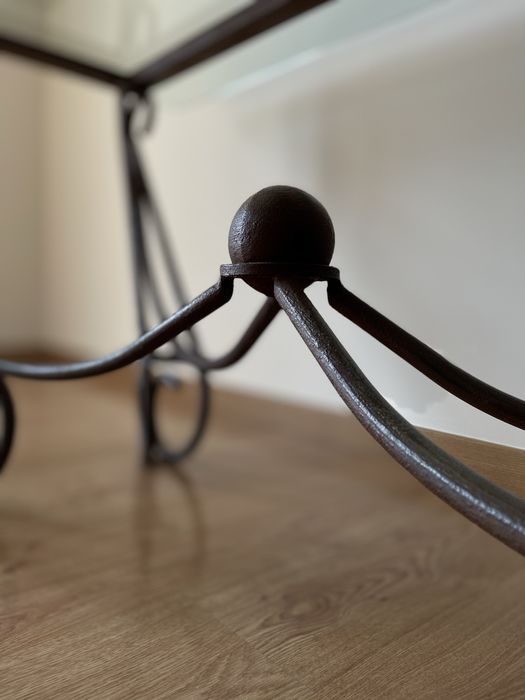 Mesa de jantar com tampo em vidro e base em ferro forjado