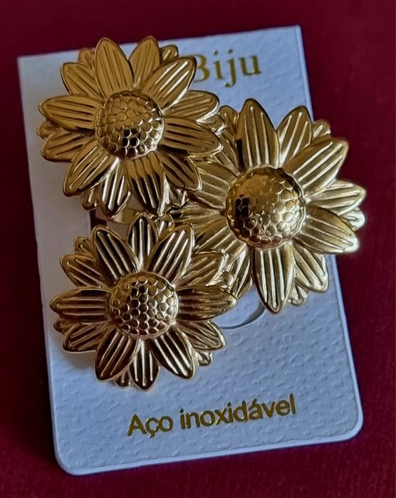 Anel dourado, em aço, formato de 3 lindas flores. Ajustável