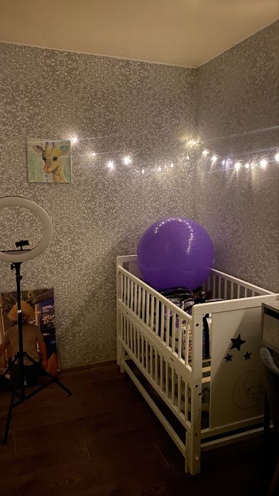 Дитяче ліжечко білого кольору з маятником