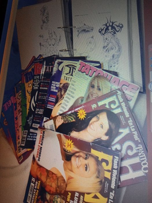 Máquina e revistas de tatuagem