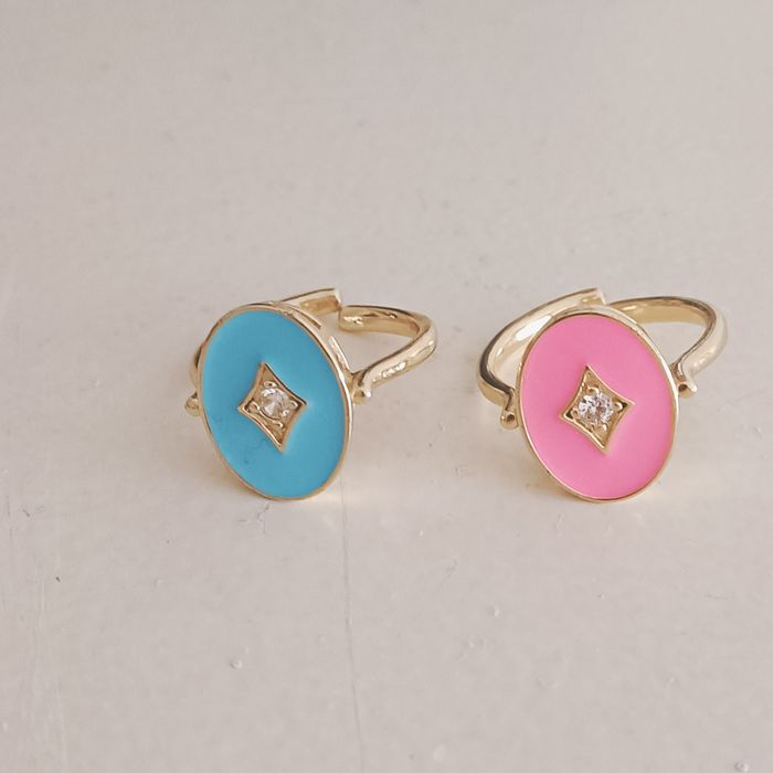 Dois anéis em latão dourado e esmalte rosa e azul.