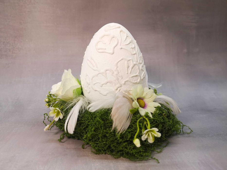 Białe jajko dekoracyjne na podstawie z mchu