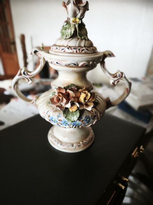 peça cerâmica decorativa ou uma peça de porcelana. Tem a forma de um vaso ou urna com duas pegas, com uma tampa separada