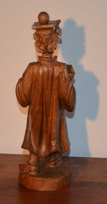 Estatueta esculpida em madeira maciça, representando um estudante universitário