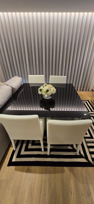 Mesa de jantar com cadeiras e tapete