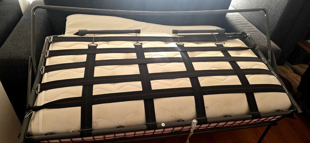 Sofá cama com colchão e sobrecolchão.