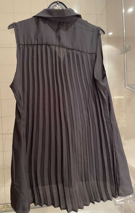 Túnica preta com elegante plissado na parte de trás