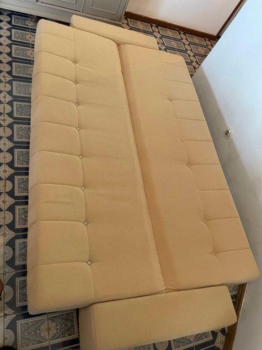 Sofá-cama bege em bom estado.