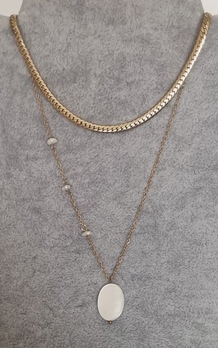 Colar duplo dourado, em aço, com pingente em madrepérola natural.
