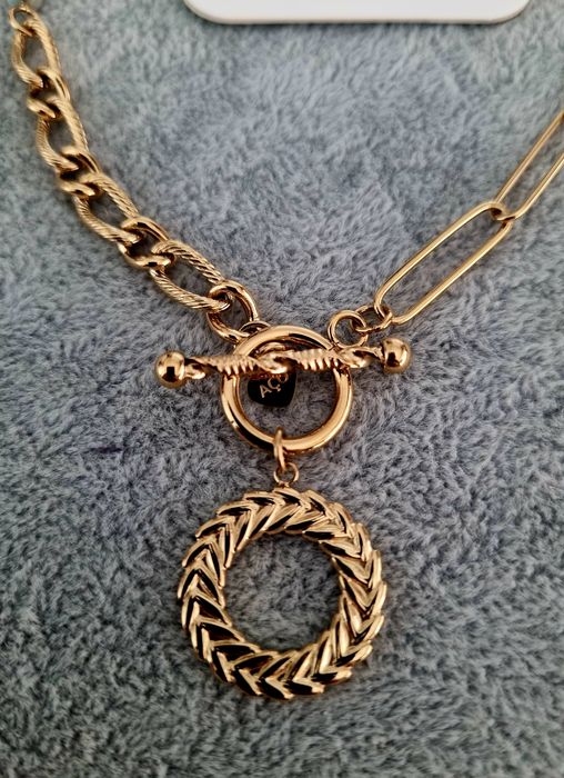 Colar dourado, em aço, assimétrico e com pedrinhas naturais coloridas.