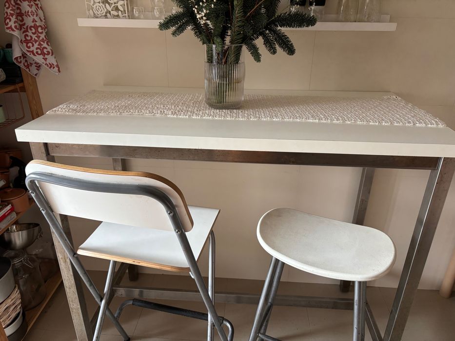 Mesa alta com duas cadeiras e um banco