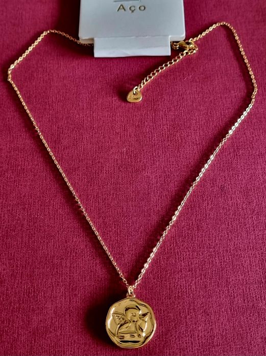 Colar dourado, em aço, com anjinho da guarda. Tem extensor