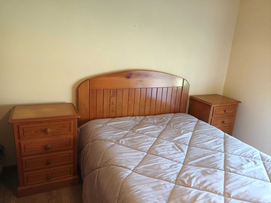 Uma cama e duas mesinhas de cabeceira