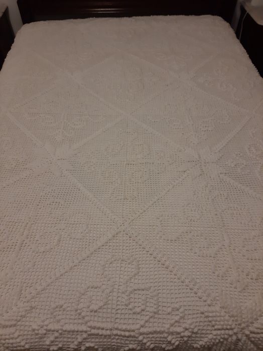 Colcha branca de renda feita à  mão .