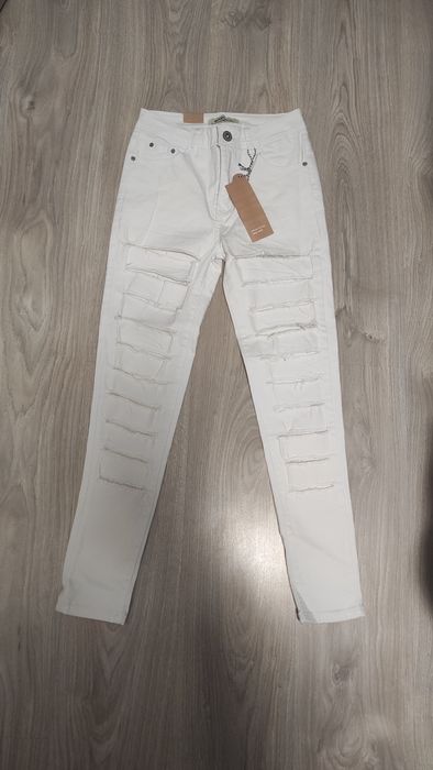 Białe dopasowane jeansy z rozcięciami rozmiar 38/M