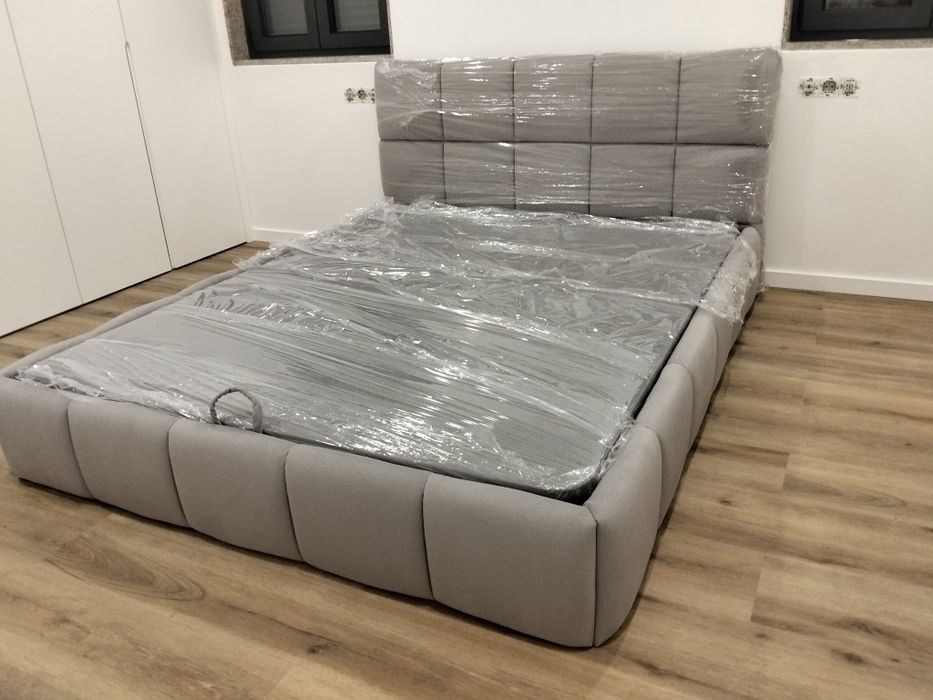Cama em tecido nova com estrado elevatória incluída.