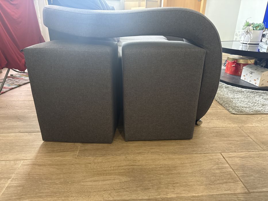 sofa cinza e conta com 4 puffs