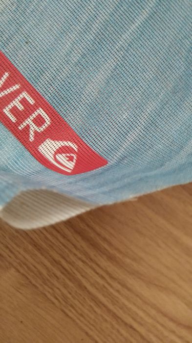 Poster Quiksilver em tela micro perfurada para pendurar.