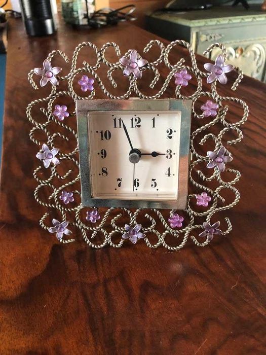 Relógio delicado em moldura trabalhada com flores em metal, bom estado