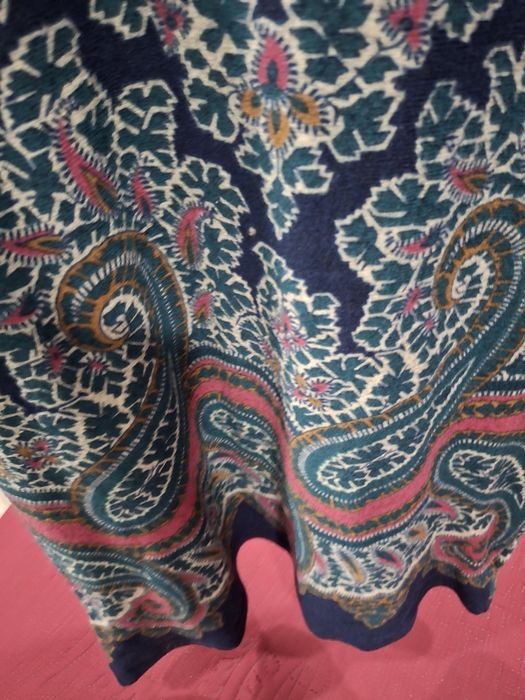Vestido com um padrão floral e paisley vibrante.

- Decote redondo.
- Mangas compridas.
- Padrão paisley em azul, verde e rosa.