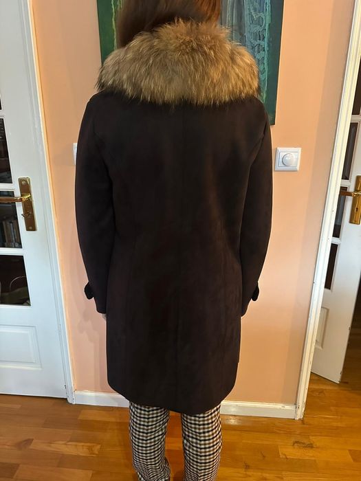 Casaco preto comprido, gola de pêlo.