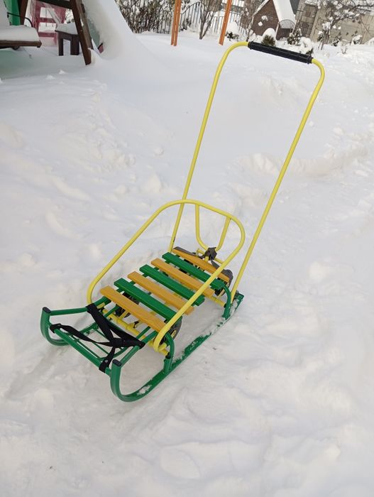 Дитячі санчата на колесах з капішоном.