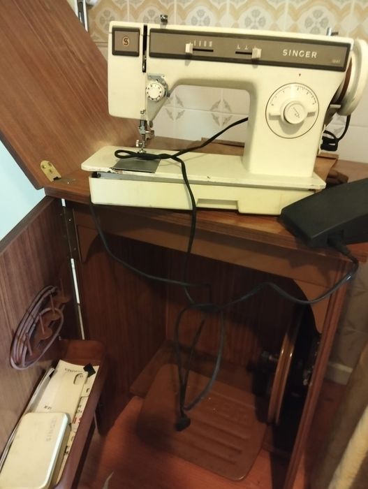 Máquina de costura Singer e móveis de madeira usados
