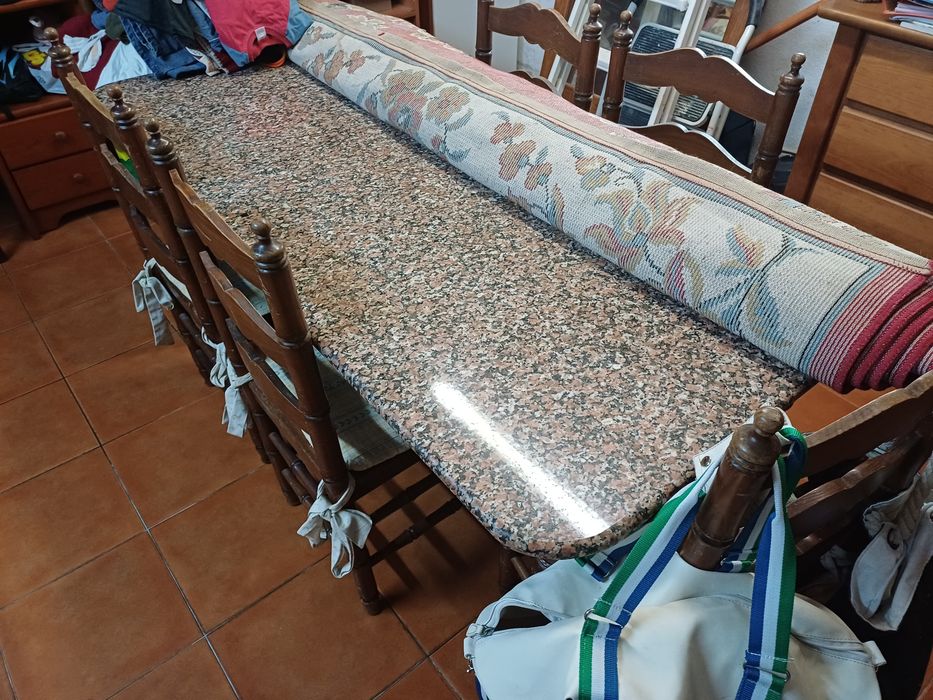 Mesa de cozinha com tampo em pedra, seis cadeiras e suas proteções