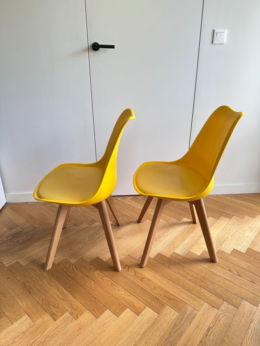 Dwa żółte krzesła na drewnianych nogach skandynawski styl
