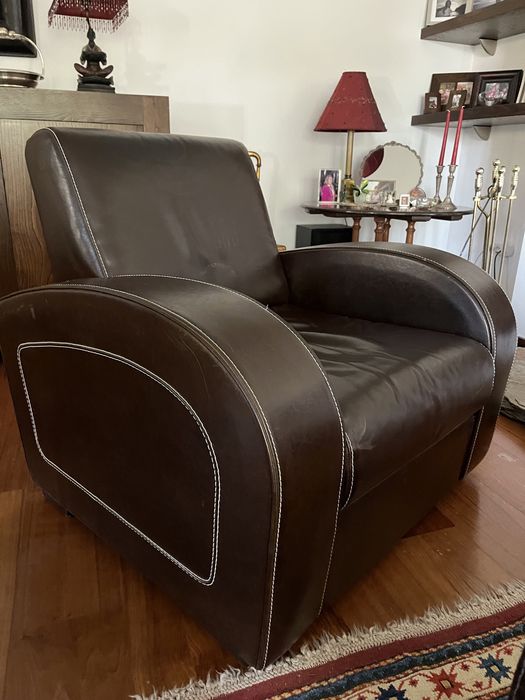 Poltrona e puff em pele castanha e pespontos brancos