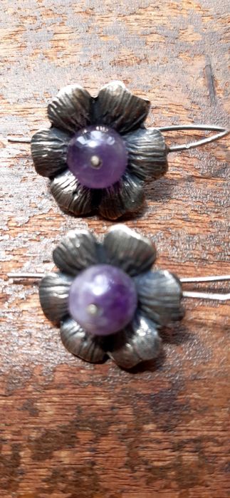 Brincos prateados em forma de flor com pedra roxa