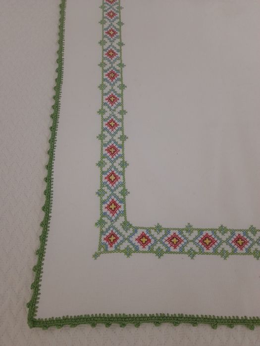 Naperon bordado em ponto de cruz, com remate feito em croché