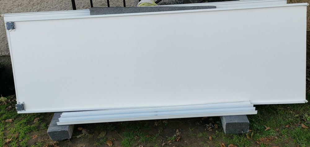 Drzwi przesuwne dwuskrzydłowe, białe. Szer. skrzydła 76cm, wys. 231cm.